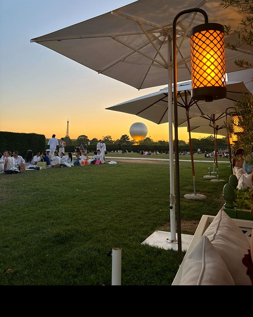 Loulou Paris, terrasse du restaurant ouverte sur le jardin des Tuileries au coucher du soleil, tour Eiffel à l'horizon